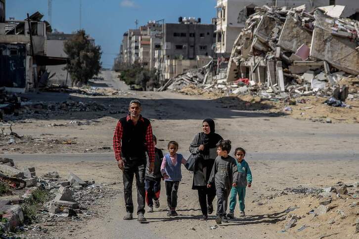 Una familia palestina camina entre los edificios destruidos de la ciudad de Gaza.