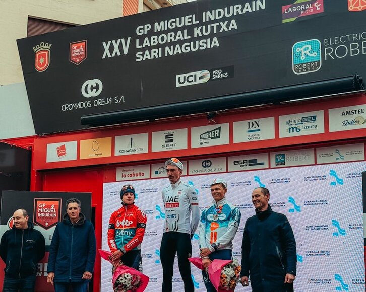 Maxim van Gils, Brandon McNulty y Oscar Onley, junto a Miguel Indurain en el podio final.