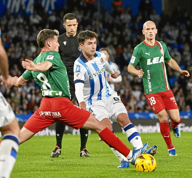 Zubimendi, autor del empate en Anoeta, pugna con Blanco ante la mirada de Guridi.