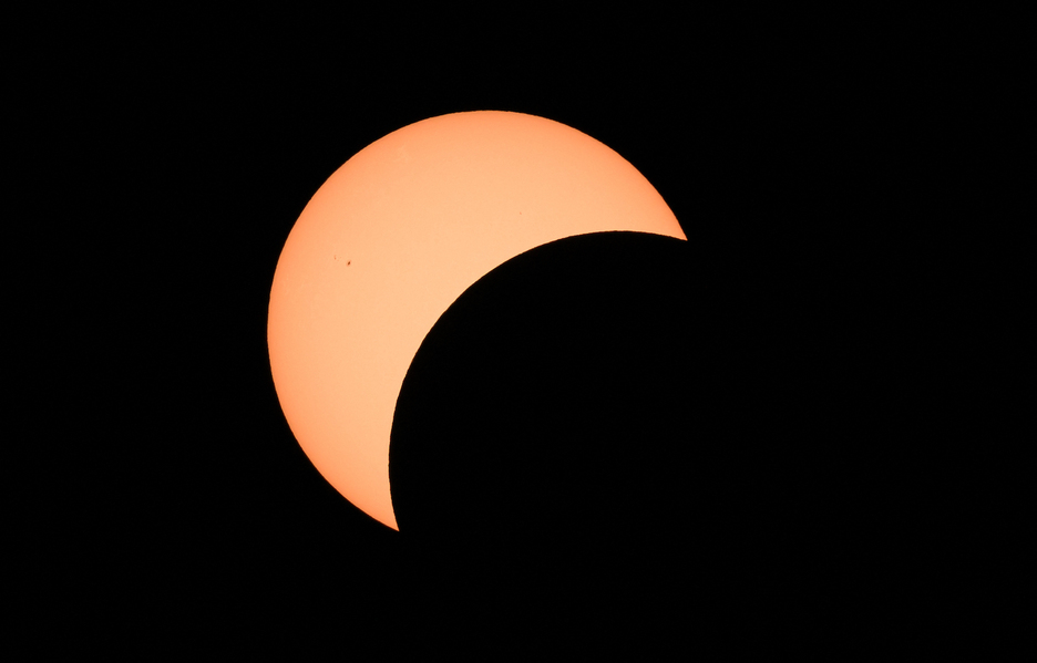 Primeras etapas del eclipse solar total muestran la luna cruzando frente al sol en Bloomington, Indiana.