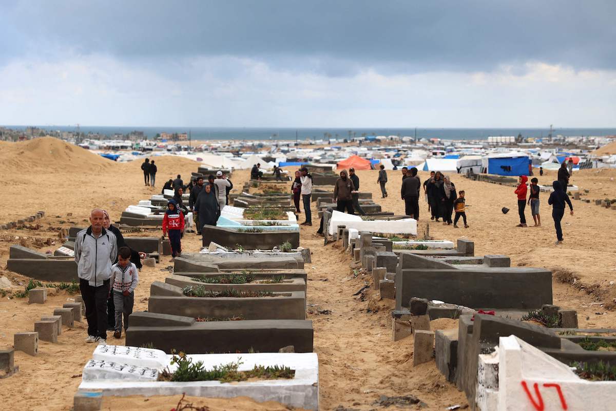 Gazatíes desplazados visitan las tumbas de sus familiares. (AFP)