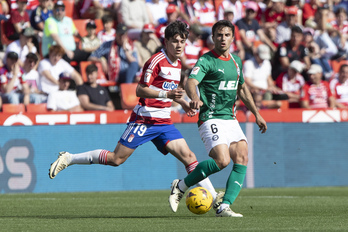 Guevara baloi bat jasotzen, atzean Pellistri daukala, Alaveseko jokalari ohi bat.