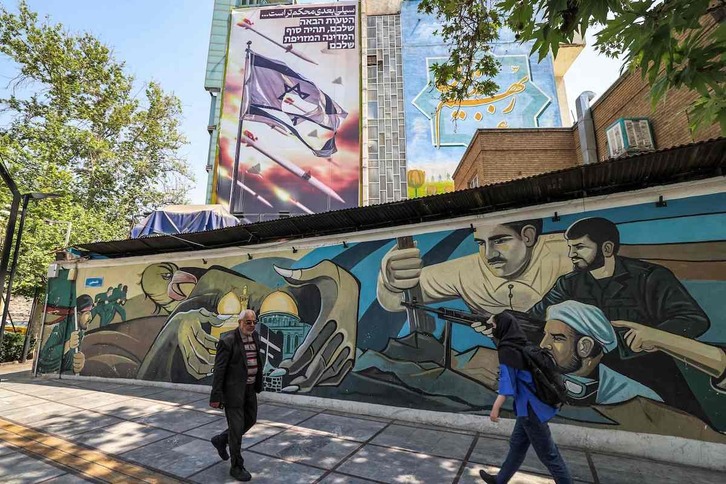 Ciudadanos iraníes pasan eh Teherán ante un mural relativo al ataque a Israel. En farsi, se puede leer «el siguiente golpe será más fuerte». En hebreo, «vuestro próximo error será el último».