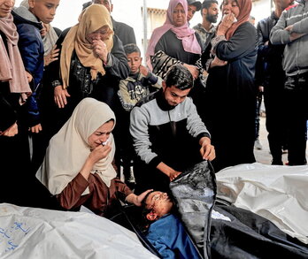 Varias mujeres lloran ante los cuerpos de varios familiares muertos en un ataque israelí.