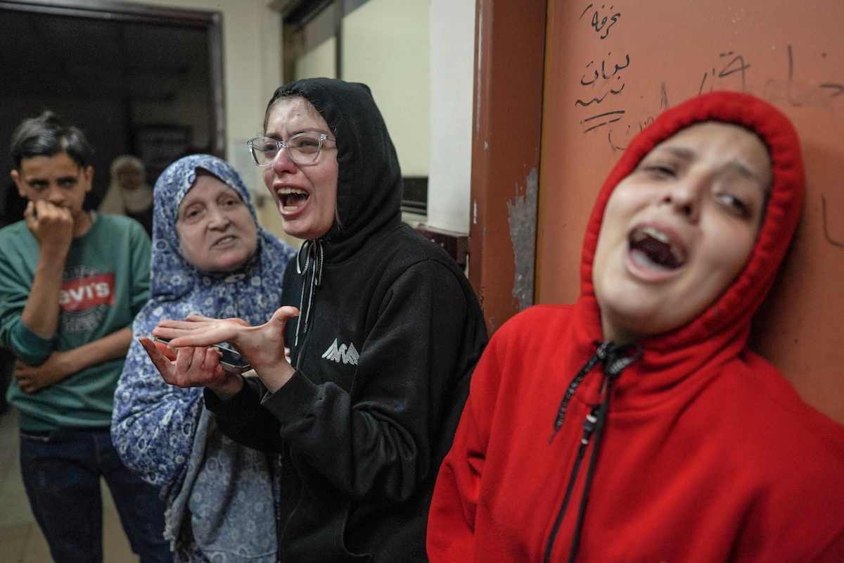 Varias mujeres palestinas lloran por la muerte de familiares en un bombardeo israelí en Deir Balah. (AFP)