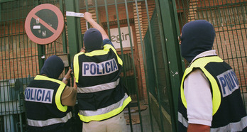 Policías encapuchados colocan precintos de cierre en la puerta principal de ‘Egin’ en Hernani el 15 de julio de 1998.