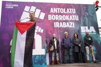 Mitxel Lakuntza interviene en Bilbo, con la bandera palestina en el atril.