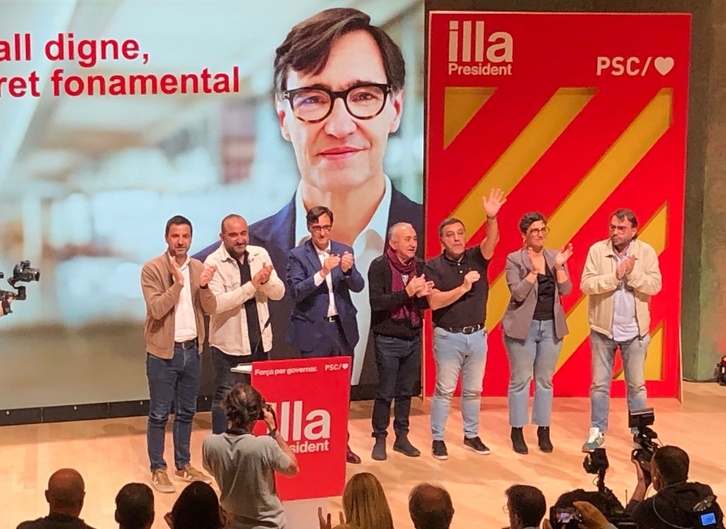 Carnero, con la mano levantada en el acto de este viernes junto al candidato Illa.