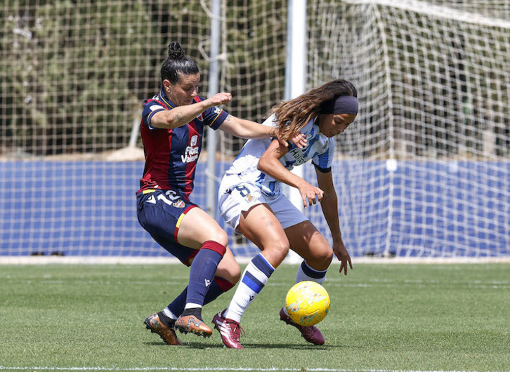 Andreia Jacinto intenta proteger el balón ante Leire Baños.