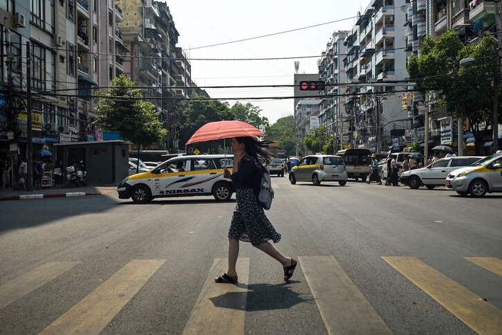Una mujer se protege del calor en Yangon, Myanmar.