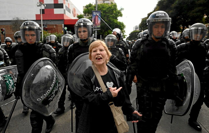 Emakume bat poliziei biraoka, protestan ari diren elkarteetako kideak geldiarazten dituzten bitartean, Quinta de Olivosen.