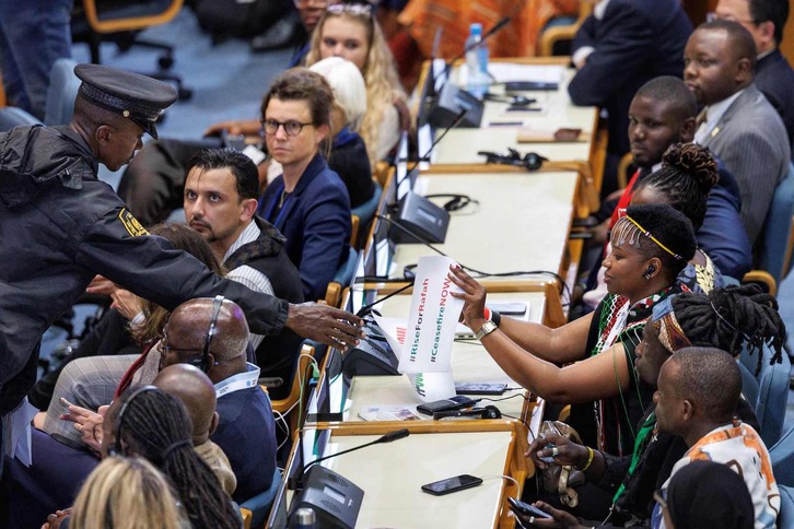 Un agente de seguridad retira a una delegación un cartel por un alto el fuego en Rafah.