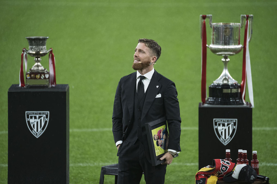 Iribarrek oparitutako argazkia eskuetan duela, harmailetara so. Iribarrek oparitutako argazkia eskuetan duela, harmailetara so.