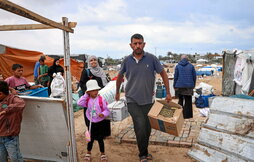 Una familia palestina desmonta su tienda y recoge sus pertenencias para huir del campamento de Rafah.