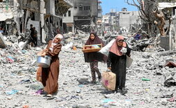 Palestinas cargan con sus pertenencias tras un bombardeo israelí en el barrio Zeitun, en la ciudad de Gaza.
