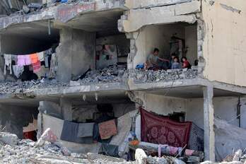  Familias palestinas, viviendo entre las ruinas de una casa destruida por los bombardeos en Rafah.