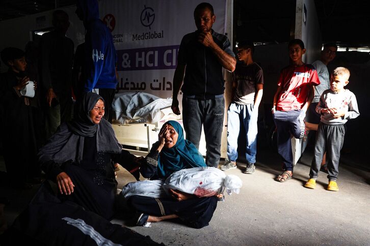 Una mujer sostiene el cuerpo de su hijo en el centro médico instalado en Tel al Sultan, en Rafah. (Eyad BABA/AFP)