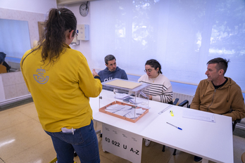 Una trabajadora de Correos entrega los votos por correo en una mesa electoral de Donostia.