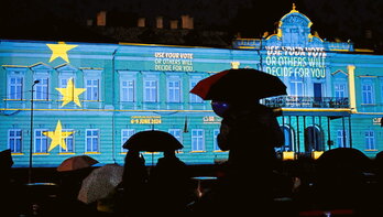 Varias personas observan las luces proyectadas sobre la fachada de la Galería Nacional de Arte, en Sofía (Bulgaría), el pasado 9 de mayo, Día de Europa.