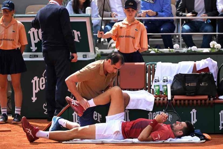 Novak Djokovic recibe tratamiento de fisioterapia en su rodilla durante su encuentro de octavos de final.