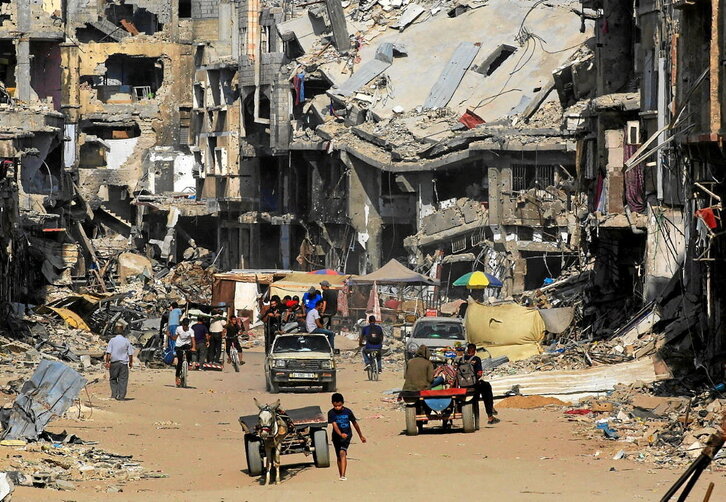 Palestinos entre las ruinas de la ciudad de Jan Yunis.