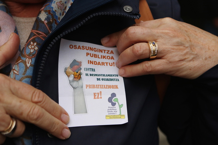 Una mujer porta una pegatina a favor de la sanidad pública.