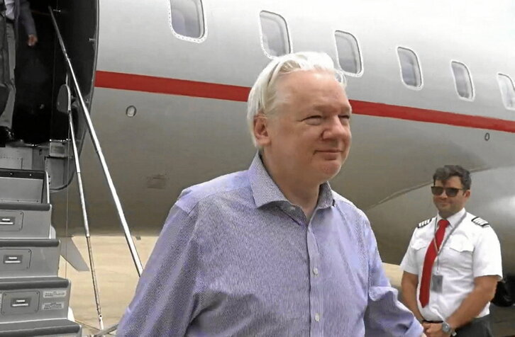 Julian Assange, en el avión que le lleva hacia Australia, previo paso por un tribunal de EEUU en las Islas Marinas del Norte.