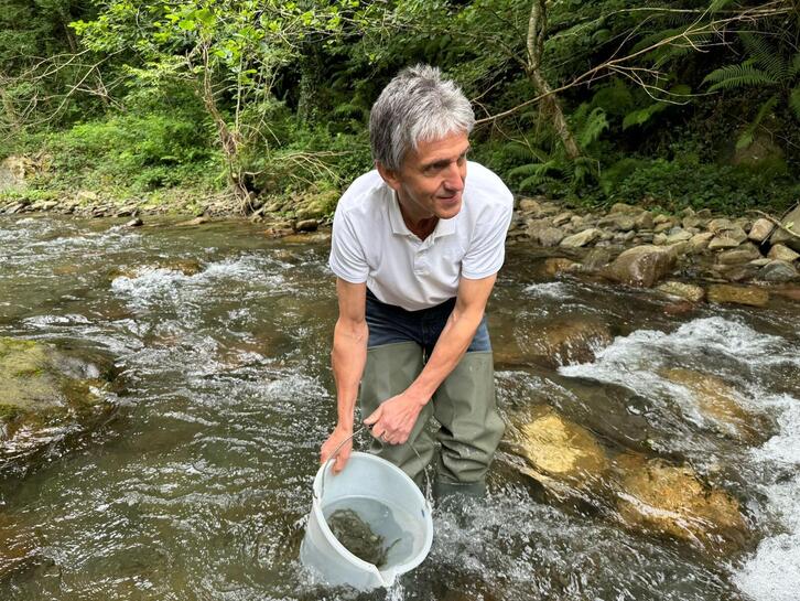 El diputado Xabier Arruti, en la operación de suelta de los salmones alevines.