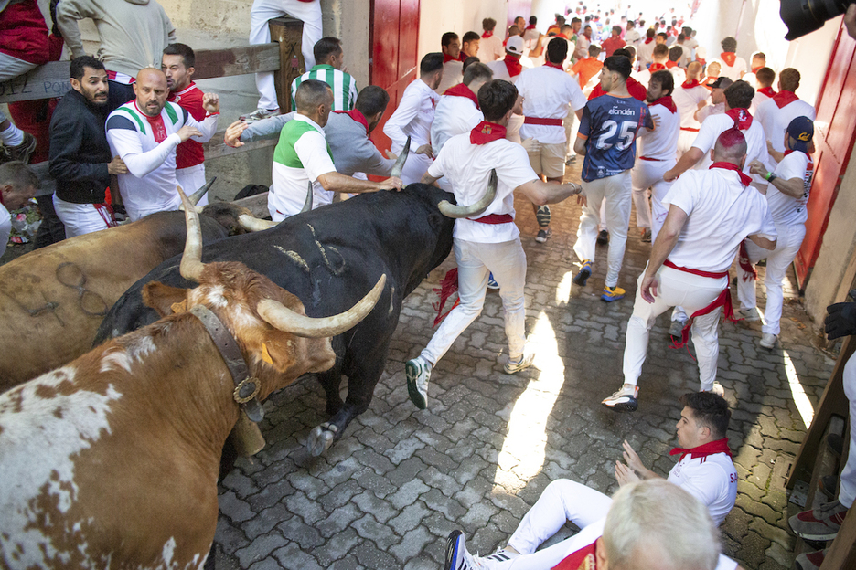 El morlado Chistoso empuja con uno de sus cuernos a uno de los mozos.