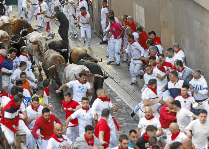 Varios mozos delante de los astados, en plena subida de Santo Domingo.