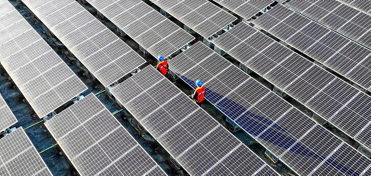 Trabajadores inspeccionando paneles solares en el tejado de una planta de energía en Fuzhou, en la provincia de Fujian, en el sur de China.