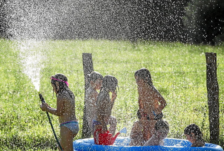 Haur talde bat freskatzen, udako egun bero batean.