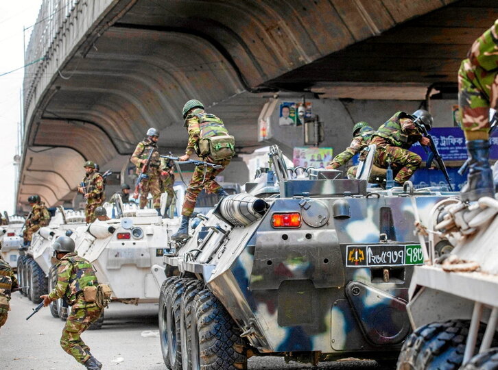 Soldados descienden de los blindados para patrullar por las calles de Dacca y dispersar las protestas.