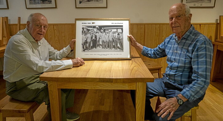 Ezkerreko orrialdean, Iñaki Egibar eta Trinido Bakeriza, 1960. urtean Erromako Olinpiar Jokoetara joan zirenen koadroa eskuan. Lerro hauen gainean, bi protagonistak, NAIZ Irratiko solasaldian.