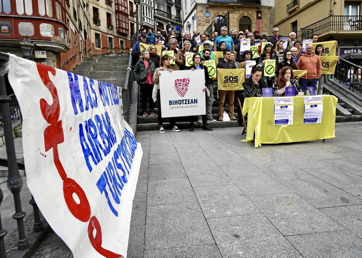 En la página anterior, concentración vecinal contra los alojamientos turísticos en Bilbo. Junto a estas líneas, turistas ven un encierro desde el balcón de una vivienda.