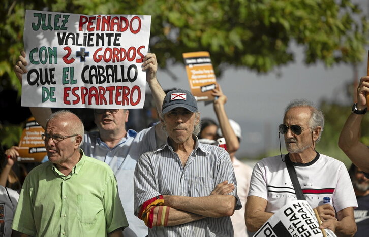 Carteles contra Sánchez y a favor de Peinado entre las personas, algunos con símbolos ultraderechistas, que acudieron a la Moncloa.