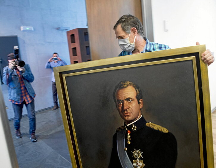 Un trabajador del Parlamento de Nafarroa retirando el cuadro de Juan Carlos I en 2020.