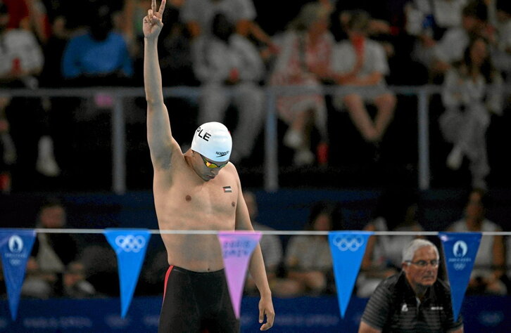El nadador palestino Yazan Al-Bawwab hace el gesto de la paz antes de competir en 100 metros espalda.
