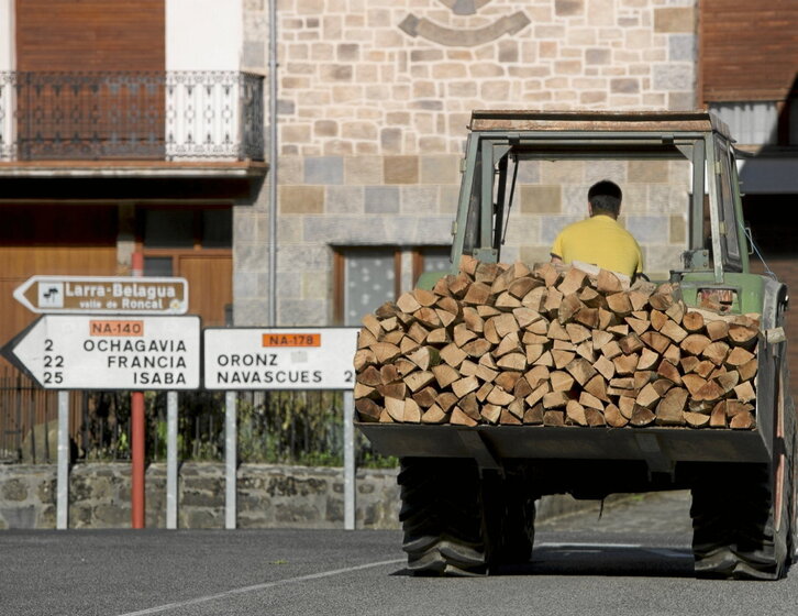 Un tractor transporta madera en un pueblo del Pirineo navarro.