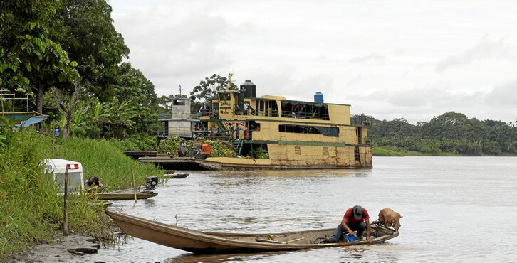 En el río Marañón, un aldeano en su canoa y un barco que transporta personas y mercancías como plátanos.