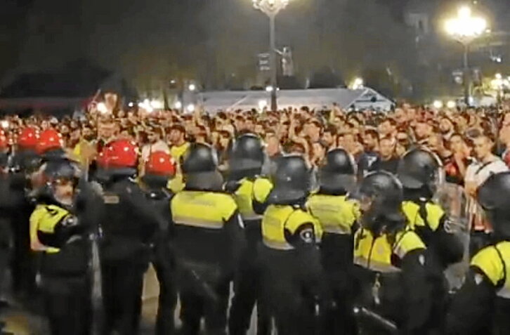 Agentes de Policía Municipal y Ertzaintza frente a comparseros y ciudadanos que denunciaron la intervención del domingo.