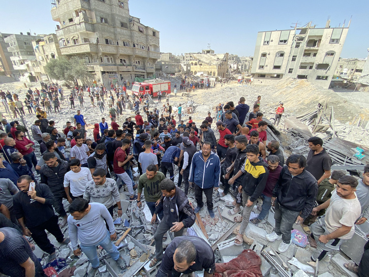 Palestinos, entre los escombros de un edificio destruido por Israel en Gaza, la pasada semana.