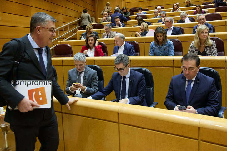 El senador de Compromís, Enric Morera, pasa por delante de los ministros Fernando Grande-Marlaska, Félix Bolaños y José Manuel Albares en el hemiciclo de la Cámara Alta.