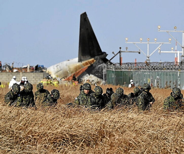 Militares surcoreanos peinan la zona del avión estrellado.