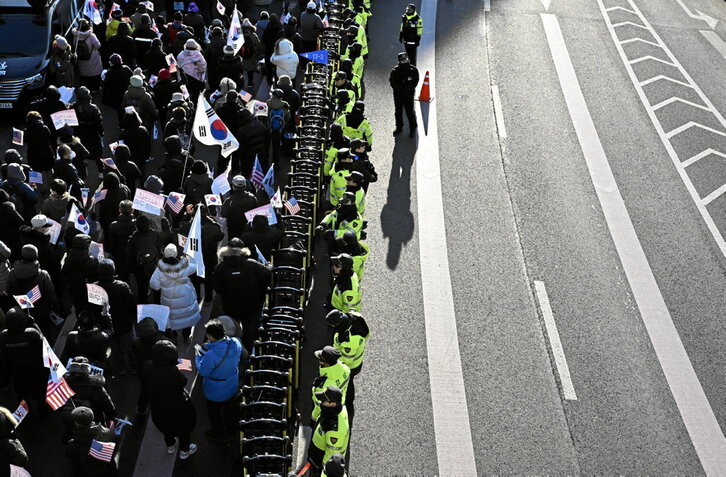 La Policía vigila a los partidarios de Yoon Suk-yeol, reunidos cerca de su residencia en Seúl.