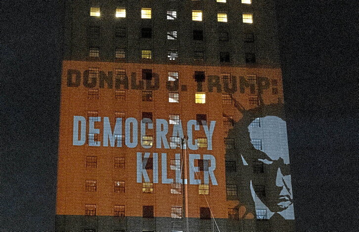 Un grupo de activistas proyecta en el edificio de los juzgados de Manhattan un mensaje llamando a Donald Trump «Asesino de la democracia».