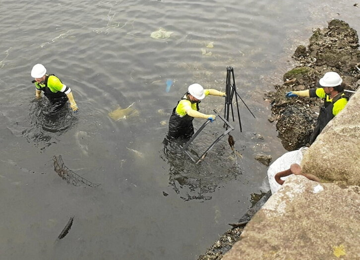 Langileak, hondakinak Urumeatik ateratzen.
