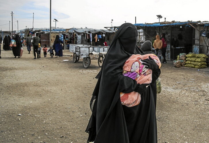 Una mujer, con un bebé, en una de las «calles» del campamento de Al Hol.