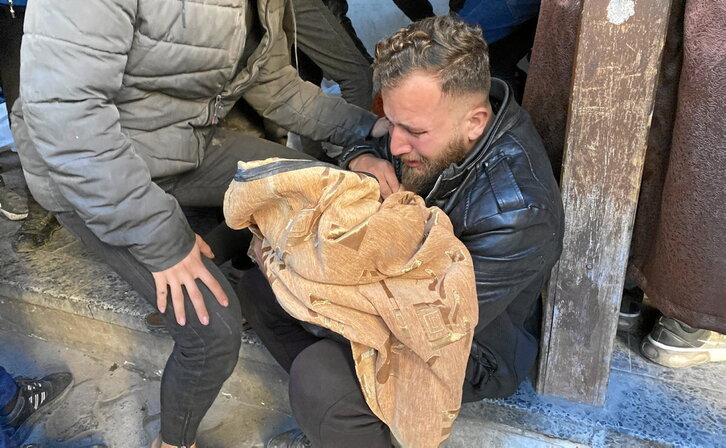 Un padre sostiene a un niño muerto en un ataque a la escuela Salah al-Din, en ciudad de Gaza.