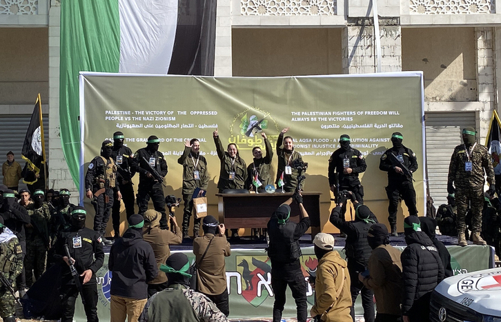 Las cuatro soldados israelíes liberadas por Hamas saludan desde un escenario dispuesto por las brigadas de Al Qassam antes de ser entregadas a la Cruz Roja